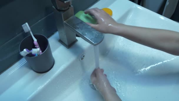 女の子はトイレのシンクに石鹸と水で手を徹底的に洗い 手のハイアングルの中のビデオ タップ 白いシンクを洗うことによって 適切な手の衛生に従います — ストック動画