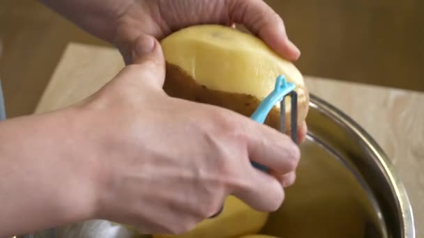 Blanke Vrouw Schilt Aardappelen Met Een Schiller Een Metalen Schaal — Stockvideo