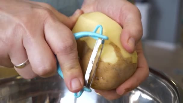 Kaukaska Kobieta Obiera Ziemniaki Obieraczką Metalowej Miski Rodzinny Obiad Domowym — Wideo stockowe