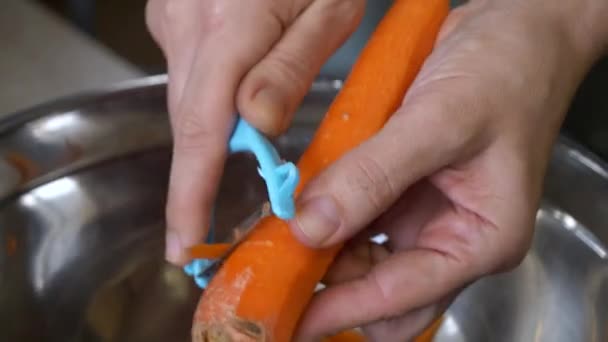 Die Kaukasierin Schält Eine Karotte Mit Einem Schäler Eine Metallschüssel — Stockvideo