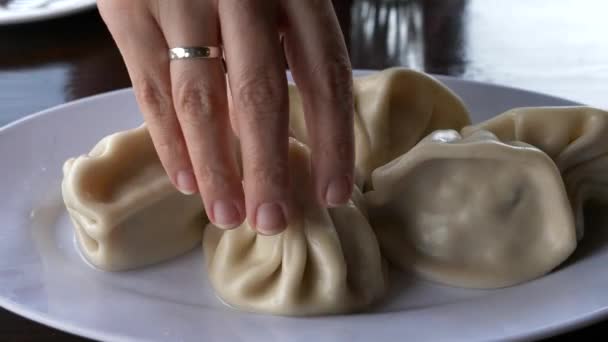 Γυναικεία Χέρι Λαμβάνοντας Παραδοσιακά Γεωργιανά Ζυμαρικά Khinkali Από Λευκό Πιάτο — Αρχείο Βίντεο