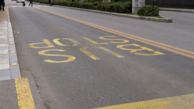 Yaya geçitleri otobüs şeridinde dur işareti olan sarı boyalı asfalt bir yola basılmış..