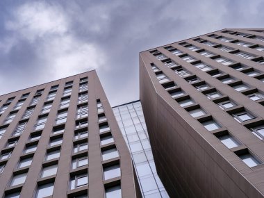 İki gökdelen kasvetli bir gökyüzüne yükseliyor, modern mimari tasarımı sergiliyorlar..