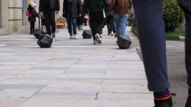 Yaya geçidinde yaya geçidi boyunca yürüyen yayalar, bacaklarının üzerinde zemin kattan ateş ediyorlar. Tiflis, Gürcistan - 30 Mart 2024.