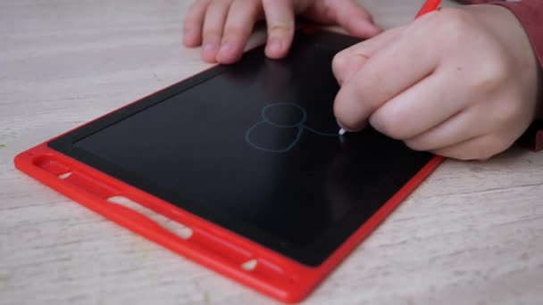 赤い落書きボードに花を描く子供の手のクローズアップビュー — ストック動画