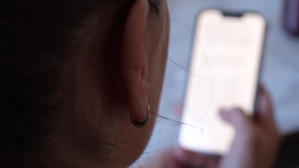 Kobieta Patrząc Jasny Biały Ekran Smartfona Pomieszczeniach Ots Shot — Wideo stockowe