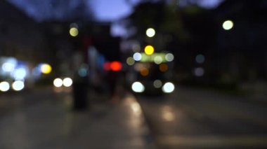 Şehirdeki otobüslerin ve arabaların gece aydınlık otobüs duraklarının yanında parlayan Bokeh sokak ışıklarıyla hareketsiz kaldı..