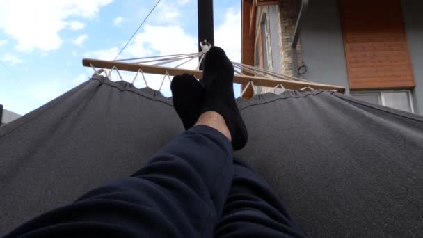 Hamakta Uzanan Erkek Bacaklarının Görüntüsü Arka Planda Açık Bir Gökyüzü — Stok video