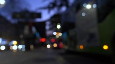 Şehirdeki otobüslerin ve arabaların gece aydınlık otobüs duraklarının yanında parlayan Bokeh sokak ışıklarıyla hareketsiz kaldı..