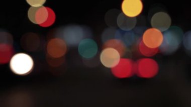 Geceleyin hareket eden arabaların renkli bokeh ışıkları ile bulanık arkaplan.