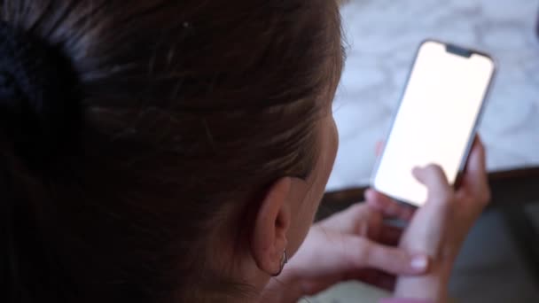 Женщина Смотрит Яркий Белый Экран Смартфона Помещении Снимок Ots — стоковое видео