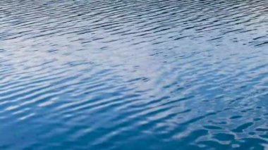 Yavaşça hareket eden temiz suyun yakın görüntüsü dalgalanır.