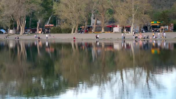 Les Gens Détendre Sur Bord Lac Pendant Soirée Plan Grand — Video