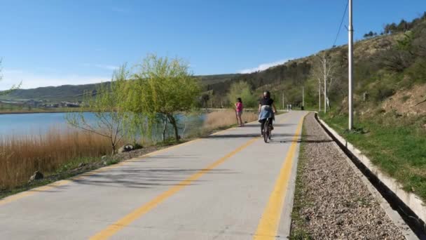 Grupo Jóvenes Ciclistas Montando Bicicletas Largo Pintoresco Sendero Lacustre Rodeado — Vídeos de Stock