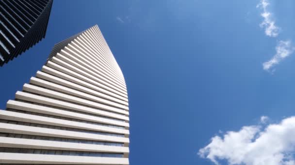 黑白相间的螺旋形摩天大楼高耸着蓝天 白云蓬松 射得很低 — 图库视频影像