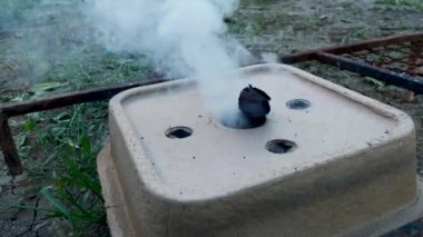 Kömür ateşleme kutusu, tutuşturulmuş ve için için için yanan, duman yayan, yakın çekim.