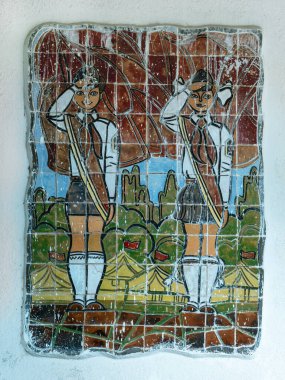 Genç Öncüler 'in çadırların önünde selamladığı klasik komünist mozaiği. Renkli küçük fayanslarla yaratılan karoda öncülerin geleneksel üniformaları sergileniyor. Betania, Gürcistan - 4 Haziran 2024.