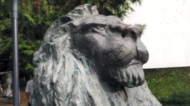 Gündüz vakti halka açık bir parkta görkemli bir aslan heykeli başı..