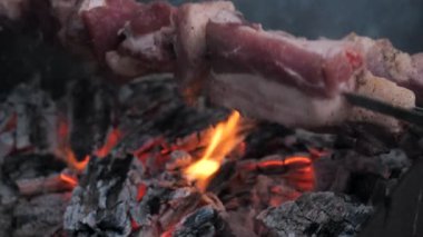 Lezzetli et şişleri arka bahçede parlayan kömürlerin üzerinde ızgara yapıyor. Arka bahçedeki barbekü setinde ızgara et pişiriyorum..