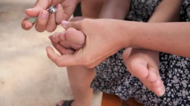 Annem dışarıda rahat bir ortamda çocuklarının ayaklarını tırnaklarıyla kesiyor..