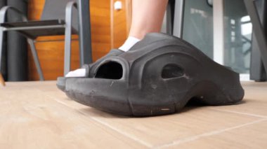 Bir insan giymeye hazır şık siyah platform sandaletleri alır. Evde rahatlamak için lastik sandalet ayakkabısı seçiyorum..