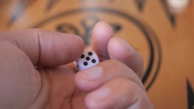 Bir oyuncu eli tavla oyunu tahtasında zar atıyor, yakın çekim..