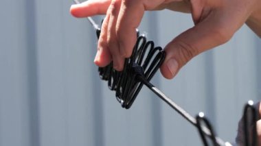 Çamaşır ipine metal mandallar takarak çamaşır makinesini kesen eller. Güneşli bir günde çamaşırları dışarı asmak.