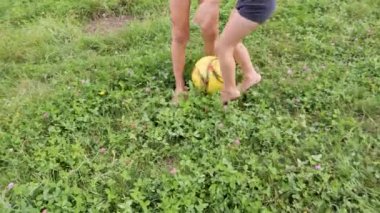 Çocuklar güneşli bir günde bahçede futbol topuyla oyun oynamaktan hoşlanırlar. İki çocuk arka bahçede futbol topuyla oynarken eğleniyor..
