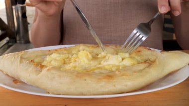 Lokantalar, erimiş peynir ve yumurtayla dolu geleneksel bir ekmek olan Khachapuri 'nin tadını çıkarırlar..