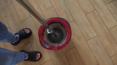 Profesyonel hademe ahşap zemini iyice temizler, etkili paspas yıkama ve hijyenik bakım için özel döner kova kullanır.