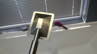 Profesyonel tesisatçı su basıncını kontrol ediyor, detaylı banyo tamiri sırasında krom duş başlığını test ediyor, düzgün kurulum ve işlevselliği sağlıyor.