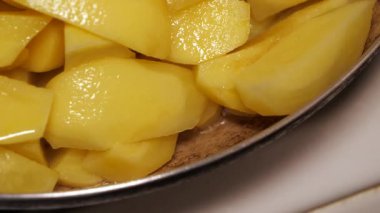 Sıcak patates cipsi cızırdıyor, tavada kahverengileşiyor.