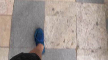 Kiremit kaplı zeminde yürüyen insanların pov görüntüsü..