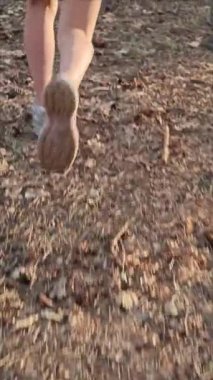 Çocuk dolambaçlı orman yolunda koşuyor, açık hava macerasından zevk alıyor.