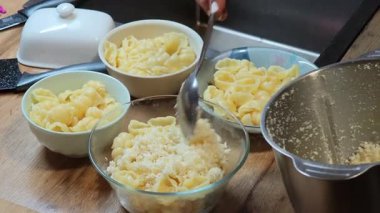 Rendelenmiş parmesan peyniri makarna kabuklarına eklenir. Lezzetli bir tarifin sonraki aşaması için hazırdır.