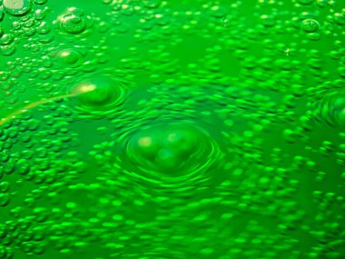 Yeşil köpüklü, köpüklü, ferahlatıcı yeşil su eşmerkezli daireler oluşturarak büyüleyici bir görsel yaratıyor.