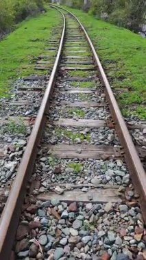 Yeşil arazide dönen eski tren yolu.