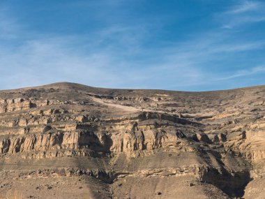 Uçsuz bucaksız gök kubbenin altında yükselen kayalık dağ sırtı dramatik jeolojik oluşumları ve engebeli araziyi gözler önüne seriyor.