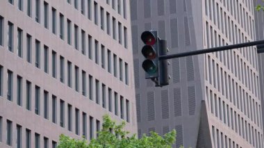 Modern bir binanın önünde trafik ışığı kırmızıdan yeşile dönüyor.