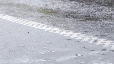 Beyaz çizgili asfalt yol yüzeyine yağmur yağıyor