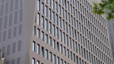 Modern bir binanın önünde trafik ışığı kırmızıya dönüyor.