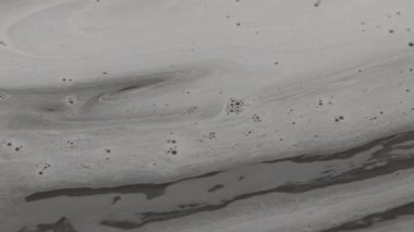 Su yüzeyinde yüzen gri köpük ve kabarcıklar