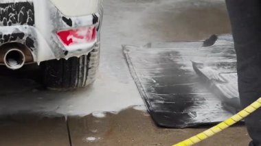 Araba temizleme, plastik araba paspaslarını sabun ve suyla yıkama.