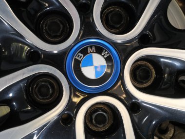 Üzerinde BMW logosu olan krom rozet, parlak bir otomotiv tekerleğinin kenarına monte edilmiş. Tiflis, Gürcistan - 1 Nisan 2025.