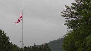 Gökyüzünde bayrak direğinde dalgalanan Gürcistan bayrağı