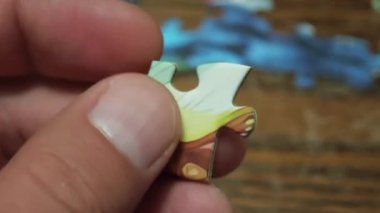 Renkli bir yapboz parçasını döndüren insan elleri