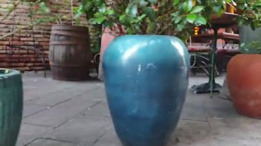 Renkli vazolar ve yemyeşil bitkiler açık hava restoranlarının avlusunda rahat bir atmosfer yaratıyor.