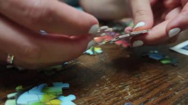 Ahşap masada renkli yapboz parçaları birleştiren kadın.