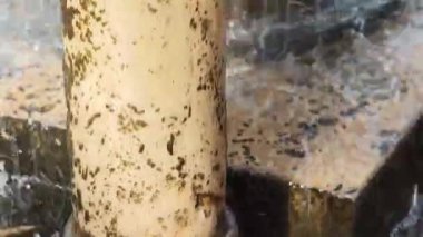 Su, halka açık bir çeşmenin ayrıntılı sütunlarına zarifçe çağlar.