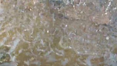 Suyun hareketini ve dokusunu yakalayan eski, süslü bir su çeşmesinin detayları.